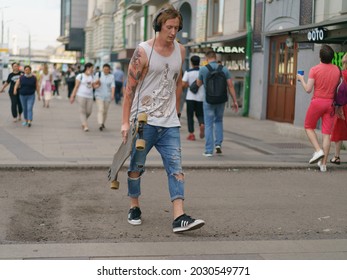 Moscow, Russia - July 21, 2021: Young Skateboarder At City Street In Summer Day. He Carrying Out The Skateboard. Extreme Sports Is Very Popular Among Youth. Sports Season During Coronavirus Pandemic