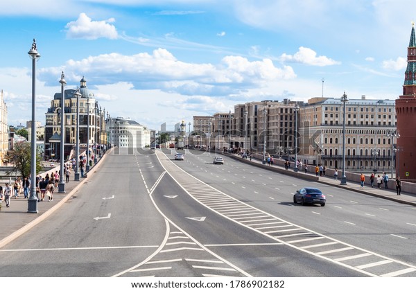 MOSCOW, RUSSIA - JULY 25, 2020: view of Bolshoy\
Moskvoretsky bridge over Moskva river with walking people and cars\
during city sightseeing tour on excursion bus in Moscow city on\
summer day