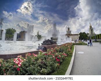 MOSCOW, RUSSIA - JULY 29, 2021: Tourists viewing the Stone Flower fountain at the Exhibition Center VDNH in summer sunny day in Moscow, Russia on July 29, 2021.
