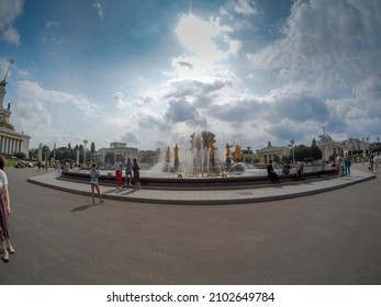 MOSCOW, RUSSIA - JULY 29, 2021: Tourists viewing the Friendship of Peoples fountain at the Exhibition Center VDNH in summer sunny day in Moscow, Russia on July 29, 2021.