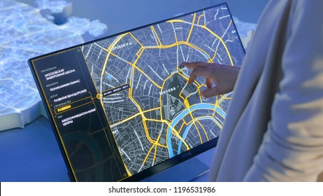 MOSCOW, RUSSIA - July 30, 2018: Smart City Exhibition. Woman using interactive touchscreen display with virtual map of Moscow at modern technology show