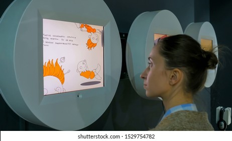 MOSCOW, RUSSIA - JUNE 05, 2019: Space Expo. Woman Looking At Interactive Wall Display And Watching Video Presentation About Astronauts At Exhibition Or Museum With Futuristic Sci-fi Interior