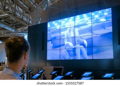 MOSCOW, RUSSIA - JUNE 05, 2019: Smart Expo. Woman Sitting And Watching Video Presentation About Tolerance On Large Wall Interactive Display At Science Exhibition, Trade Show, Museum Or University