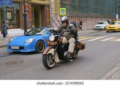 Moscow, Russia - June 1, 2022: Traffic On The Motorway In The City Center. One Motorcyclist Drives Near The Blue Convertible In Summer Day. Frontal View.