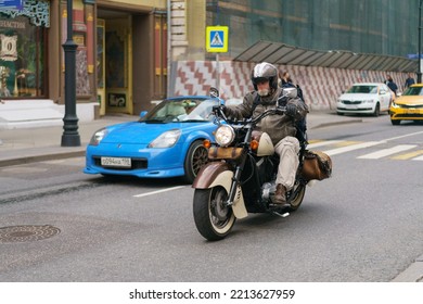 Moscow, Russia - June 1, 2022: Traffic On The Motorway In The City Center. One Motorcyclist Drives Near The Blue Convertible In Summer Day. Frontal View.