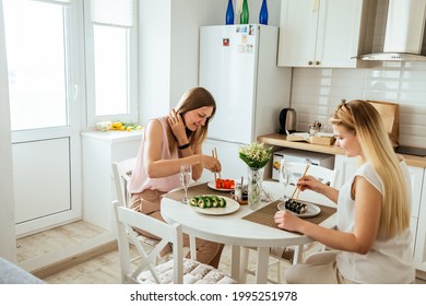 MOSCOW, RUSSIA - JUNE 11, 2021: The Family Is Having Lunch In A Bright Apartment Eating Sushi. 