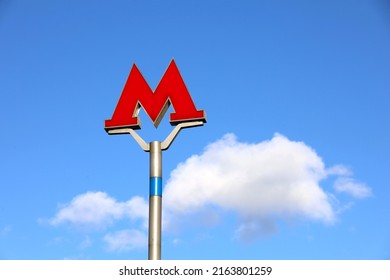 Moscow, Russia - June 2022: Metro Sign For Subway In Moscow Against The Blue Sky And White Clouds