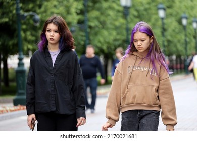 Moscow, Russia - June 2022: Two Teen Girls With Dyed Hair Walking On A Street In Summer City