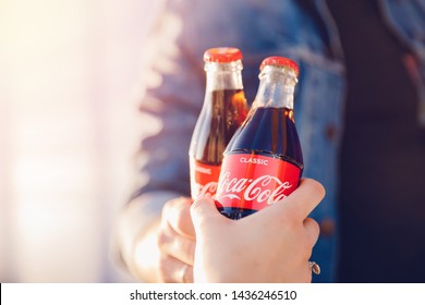 Moscow, Russia - June 27, 2019: Clink Drink Coca Cola Glass Bottle In Hands, Sunset