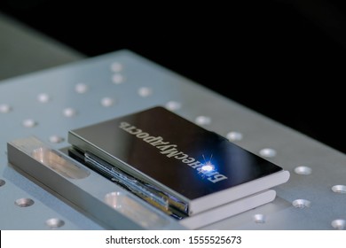 MOSCOW, RUSSIA - JUNE 30, 2019: Smart Expo. Fiber laser engraving machine marking metal business card at exhibition, trade show. Design, personalization, automated technology equipment concept