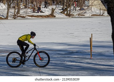 Moscow, Russia, March 16, 2022: Cyclists In The City Park Ride On Snow And Ice