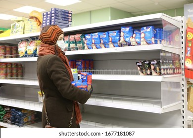 MOSCOW, RUSSIA – MARCH 19, 2020: Sanctions. Covid-19, Coronavirus In Moscow City, Russia. Shopper In Russian Store With Buckwheat. Products On Empty Shelves. Medical Mask. Retail, Retailers, Trade