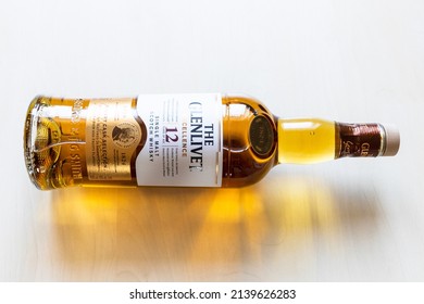 Moscow, Russia - March 20, 2022: lying bottle of 12 years old Glenlivet single malt Scotch whisky on pale table. Glenlivet distillery was founded in 1824 and has operated almost continuously since