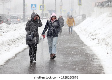 Moscow, Russia - March 2021: Defocused View To People Walking On Street During Heavy Snowfall. Blizzard In A City, Cold Weather At Early Spring