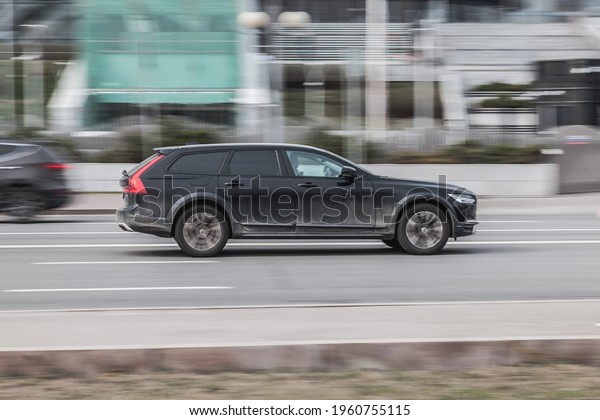 Moscow, Russia - March 2021: Fast moving Volvo\
V60 on the city road. Black compact executive car rides on street.\
Dirty auto in fast motion with blurred background. speeding in the\
city concept