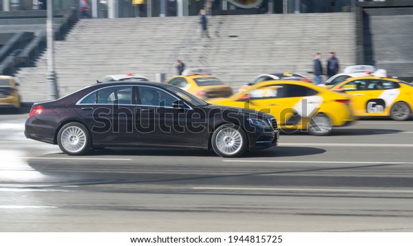 Moscow , Russia - March 2021: Motor car\
Mercedes-Benz S-class in the city street. Side view of ruby black\
Mercedes car rides on the\
road.