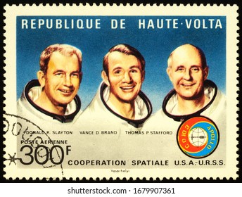 Moscow, Russia - March 22, 2020: Stamp Printed In Upper Volta Shows Crew Of Spacecraft Apollo: Donald Slayton, Vance Brand, Tomas Stafford, American-Soviet Space Mission Apollo-Soyuz, Circa 1975