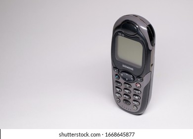 Moscow, Russia - March 3 2020: Close Up View Of Old Cell Phone With Scratched Buttons Isolated On White. Early 2000s Communication Concept.