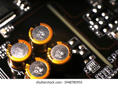Moscow, Russia - march 3 2021: Four gold-colored closeup capacitors. Dimmed lights