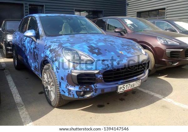 Moscow, Russia - May 09, 2019: Blue camouflage\
Porsche Cayenne parked on the street. Car is wrapped in colored\
protective film.