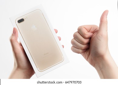 MOSCOW, RUSSIA - MAY 12, 2017: male hand holding new Apple iPhone 7 Plus Gold box on white background