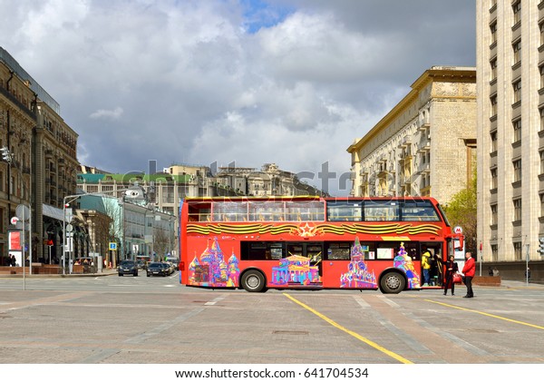 MOSCOW, RUSSIA - MAY 12,2017: Bright red\
double-decker tour buses are prowling Moscow\'s streets, giving\
visitors great view of city centre. Hop On-Hop Off tour offers\
excursions in eight\
languages