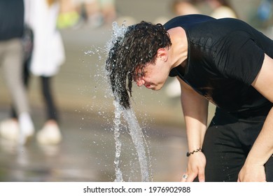 Moscow, Russia- May 17, 2021: Young Man Playing With Cold Water Of Fountains. Hot Spring Day In Big City. Youth Having Fun. He Wet His Hair With Water And Sprays Water Around