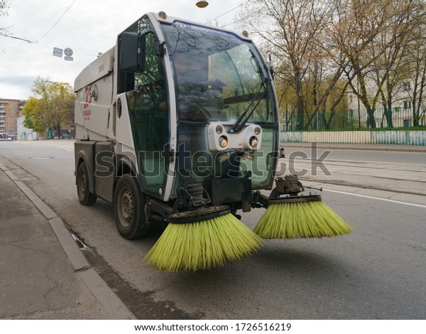 Moscow, Russia - May 2, 2020: Municipal city\
service cleans city street. Sweeper machine (car) in the working\
process of cleaning the street. Street cleaning. Coronavirus\
pandemic lifestyle.