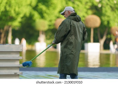 Moscow, Russia - May 20, 2021: Worker Sweeppingavenue In Public Park In Front Of Fountain. Using Brush. Occupation Theme.  Back, Rear View