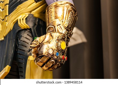 Moscow, Russia - May 2019: Сlose-Up Of Thanos's Infinity Gauntlet. Huge Gold Glove With Infinity Gems. Thanos - Character Of Fortnight Game, Comic And Marvel Movie, Production By Marvel Studio.