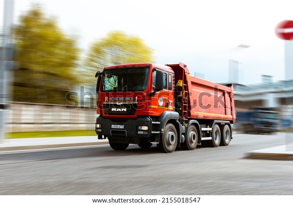 Moscow, Russia - May 2022: MAN TGS 41.440 tipper\
truck is driving in city on high speed. Dump truck MAN with red\
cabin at the city highway in\
motion