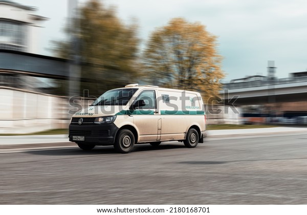 Moscow, Russia - May 2022: Side\
view of beige armored van driving on street after making a cash\
pickup. Armored cash transport Volkswagen Transporter car in\
motion