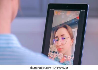 MOSCOW, RUSSIA - MAY 24, 2019: Woman Using Snapchat Multimedia Messaging App With 3d Face Mask Filter On Tablet At Home. Face Detection, AR, Beauty, Selfie, Vogue, Fashion, Trendy Concept