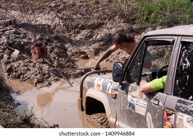 Moscow, Russia - May 25, 2019: A Man Fastens A Chain To A Car Stuck In The Mud. Off-road And Isuzy Trooper SUV Stuck In A Deep Hole.