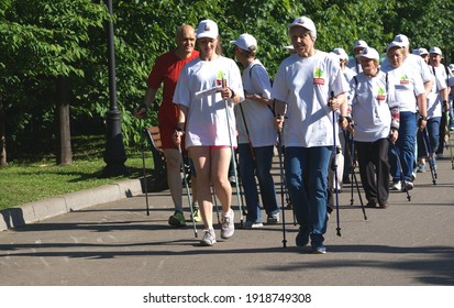 Moscow, Russia - May, 26, 2018: A Group Of Elderly Men And Women In The Summer In White Shirts In The City Are Engaged In  Hobby Sports, Nordic Walking                              