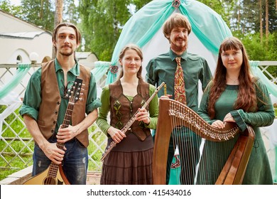 MOSCOW, RUSSIA - MAY 30, 2015: Young Musicians Of Musical Band Polca An Ri Stand Against Arch Decorated Green And White Fabrics. Polca An Ri Plays Traditional Irish Music.