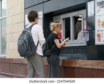 Moscow, Russia - May 30, 2020: Moscow Street Life In The Spring Day During Coronavirus Pandemic. People Have Went For A Walk And Buying Coffee In The Street Cafe. Man Put On Surgical Mask