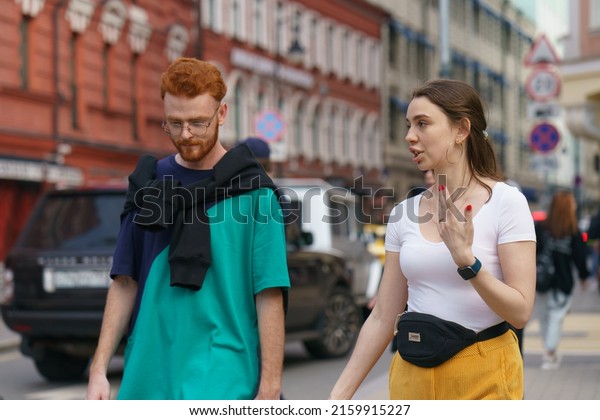 Moscow, Russia - May 30, 2020:\
Moscow city life in spring day. People go for a walk. Heterosexual\
couple of young man and woman. Frontal view. They are\
talking