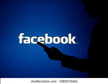Moscow, Russia - May, 4: A woman looks into the smartphone in front of Facebook logo. 