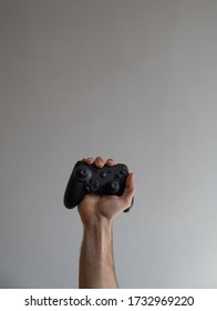 Moscow, Russia - May 5 2020: Close Up View Of Male Hand Raising Holding Black Matte Game Controller.