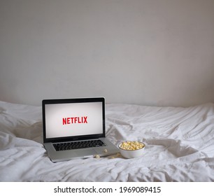 Moscow, Russia - May 5, 2021: Laptop And Popcorn On The Bed. Screensaver Netflix 
