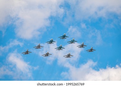 Moscow, Russia - May 5, 2021: Fighters Su-35S and Su-30SM with Su-34 bombers in the blue sky over Red Square in the tactical wing group. The aviation part of the Victory Day parade in Moscow.