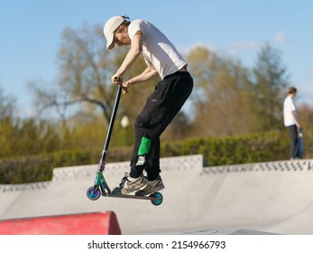 Moscow, Russia - May 5, 2022: Push Scooter Stunt On City Sport Ground N Spring Day. Boy  Jumping Over An Obstacle. Healthy Lifestyle. Extreme Sports Is Popular Among Youth.