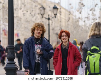 Moscow, Russia - May 9, 2021:  Two Teenagers Walking In The City Center. Nikolskaya Street. They Are Happy. One Of Them Looks Like Harry Potter. Frontal View.