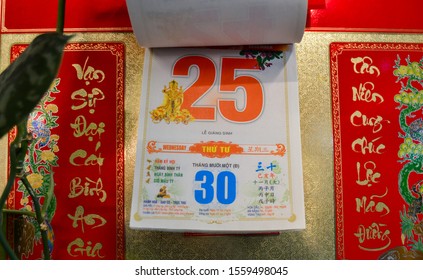 Moscow, Russia, November 2019: Detachable tear-off Vietnamese calendar with date December 25, 2019 on the wall: red numbers, hieroglyphs, beautiful gold background, lunar and solar calendar