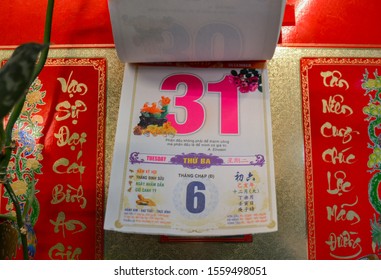 Moscow, Russia, November 2019: Detachable tear-off Vietnamese calendar with new year eve, date December 31 on the wall: red and pink numbers, hieroglyphs, beautiful gold background, lunar and solar