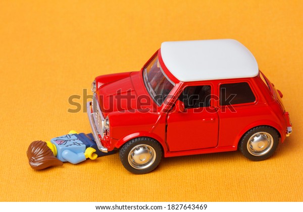 Moscow, Russia - \
October 05, 2020: Scene of a\
car crash. A toy car hit a lego women. Injured  women lying on a\
road. Car accident\
concept