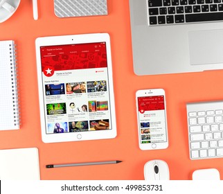 Moscow, Russia - October 13, 2016: Top View On Workplace. Iphone And Ipad Over Red Background Displaying Youtube App. YouTube Is The Popular Online Video-sharing Website, Founded In February 14, 2005