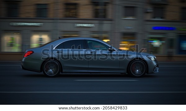 Moscow, Russia - October 2021: Evening traffic on\
the city streets. Gray Mercedes-Benz W222 S-Class driving in night\
urban road