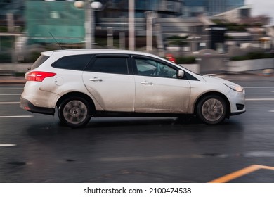 Moscow, Russia - October 2021: Ford Focus Wagon Third Generation Car, Side View. Photography Of A Modern Estate Driving On Wet Road In Moscow. White Dirty Auto In Motion